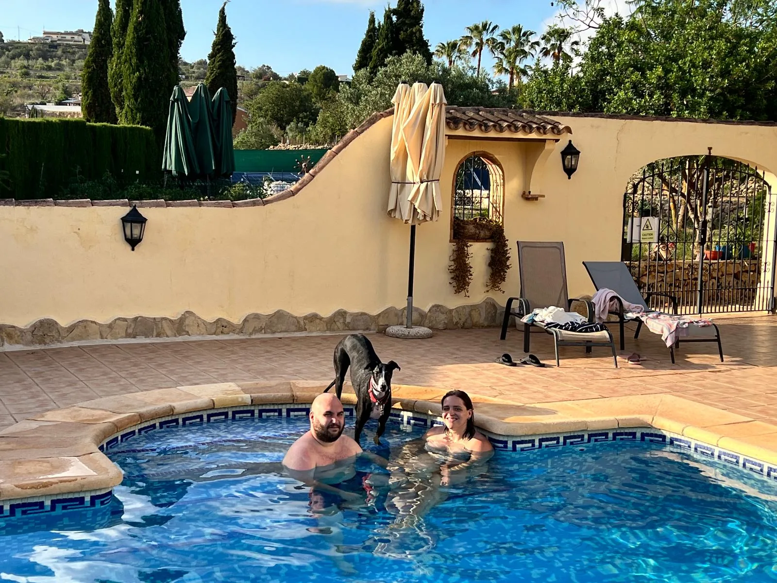 Huéspedes con perro junto a la piscina de Villa Lobos
